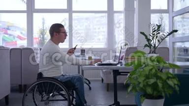 残破的餐馆老板坐在轮椅上，戴着眼镜，在餐桌上喝咖啡，用手机和工作